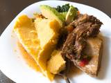 A picture of Matoke and boiled beef(ossubuco) served with veggies.