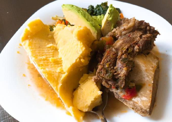 A picture of Matoke and boiled beef(ossubuco) served with veggies.