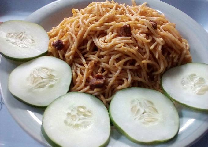 A picture of Jollof spaghetti,diced beef and vegetable.