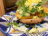 A picture of Tomato and avocado on toasted bagel with grated egg.