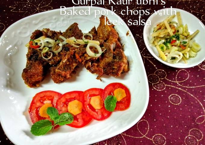 A picture of Baked pork chops with leek salsa 🐖🌿🍅🥕.