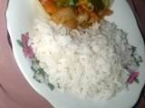 A picture of White rice with vegetable soup.