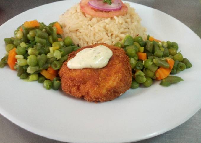 A picture of Fish fillet in breadcrumbs,braised rice and mixed vegetables.