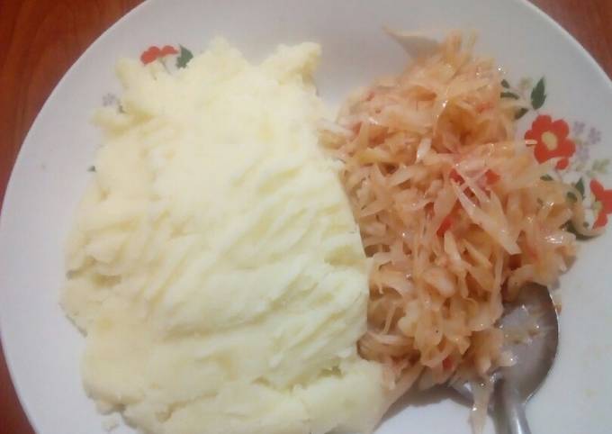 A picture of Smashed potatoes with steamed cabbage.