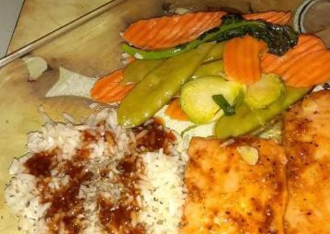 A picture of Steamed salmon,rice, vegetables w/ cherryaki sauce.