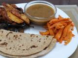 A picture of Brinjal n Potatoes with daal n roti n carrots# Indian dish conte.