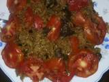 A picture of Beef pilau garnished with tomatoes.