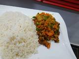 A picture of White rice with vegetable and plantain stew.