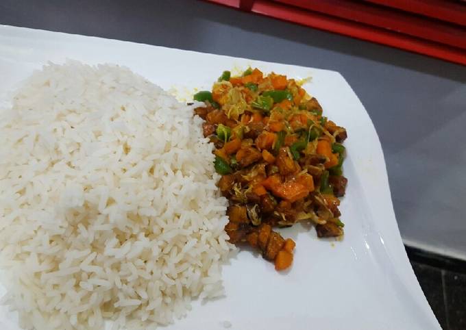 A picture of White rice with vegetable and plantain stew.