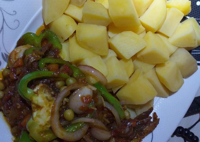 A picture of Boiled potatoes with fish in vegetable sauce.