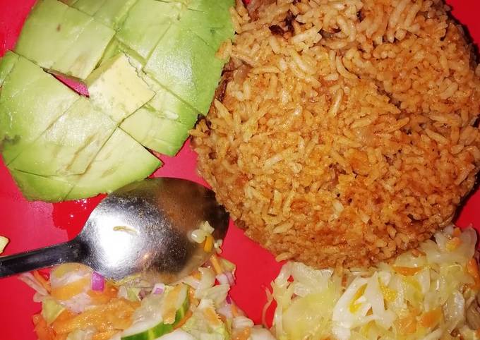 A picture of Pilau served with cabbage and salad.