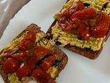 A picture of Avocado toast with fried tomatoes.