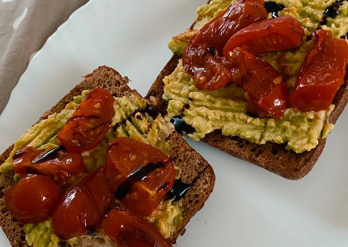 A picture of Avocado toast with fried tomatoes.