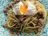 A picture of Mushroom pancetta pasta poached egg on top.