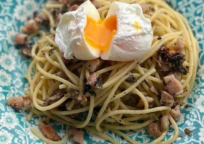 A picture of Mushroom pancetta pasta poached egg on top.