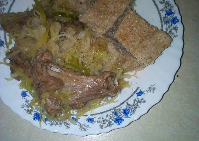 A picture of Brown ugali with mutton and cabbage.