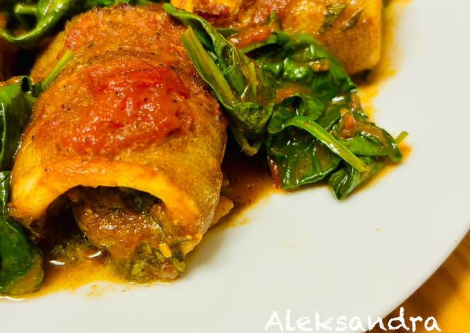 A picture of Cod rolls with tomatoes and spinach.