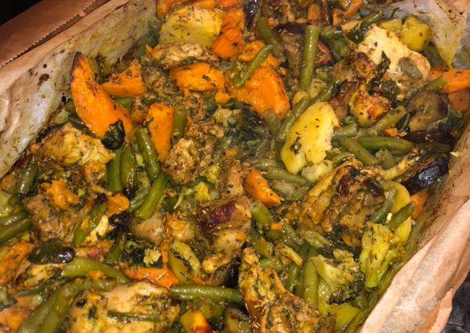 A picture of Chicken with vegetables in the oven.