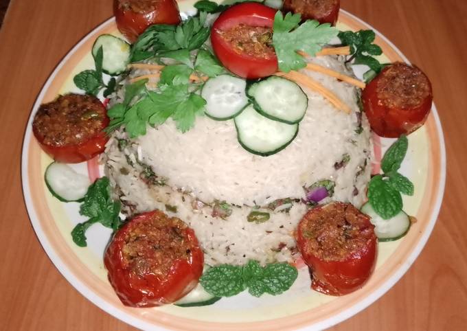 A picture of Stuffed tomatoes 🍅 with Arusha rice 🍚🧄🧅.