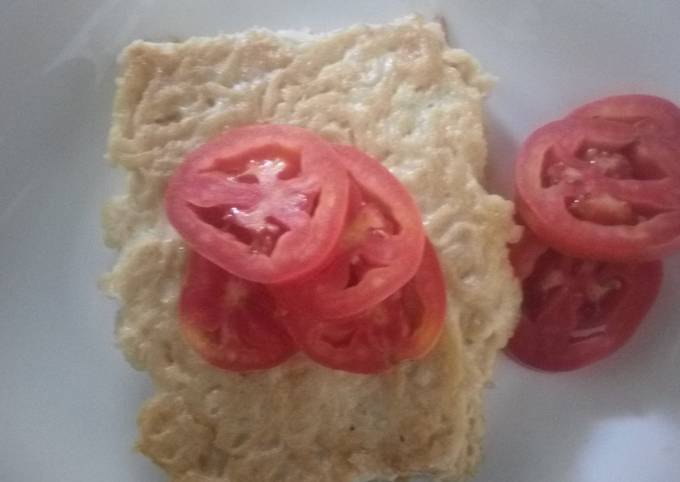 A picture of Heavy omelette with tomato slices.