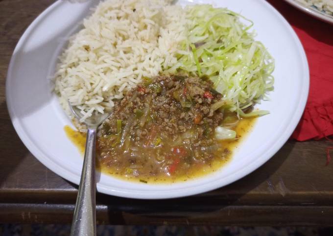 A picture of Rice with ndengu and steamed cabbage.