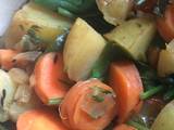 A picture of Vegetable curry with carrots, carrot tops, potatoes and spinach.