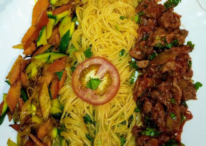 A picture of Spaghetti on tomato sauce,wet fry beef, sauteed vegetables..,.