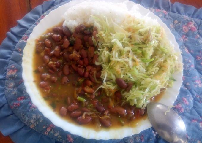 A picture of Boiled rice and fried red beans with steamed cabbages.