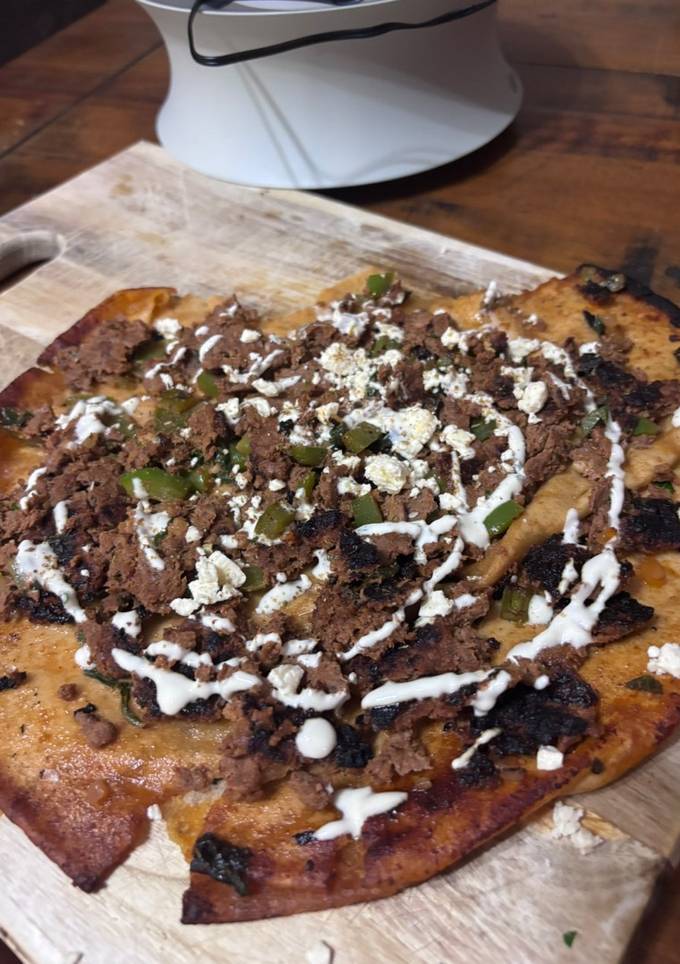 A picture of Lebanese Style Spiced Beef Pizza with homemade lemon garlic yoghurt sauce topped with Za’atar.