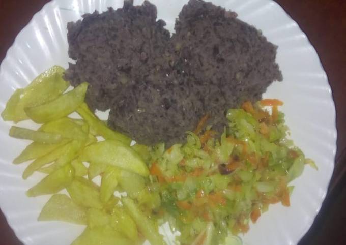 A picture of Sweet Smashed njahi and banana with steamed cabbage and fries.