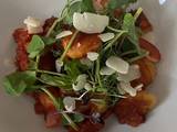 A picture of Gnocchi with mushrooms, tomato sauce and parmesan shavings.