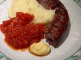 A picture of Boerewors with mashed potatoes served with a tomato chili relish.