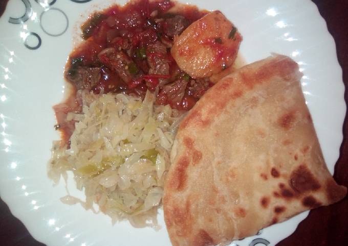 A picture of Beef stew, cabbage and chapati.