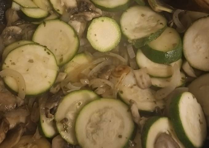 A picture of Salmon fillets with courgettes onion and mushrooms.